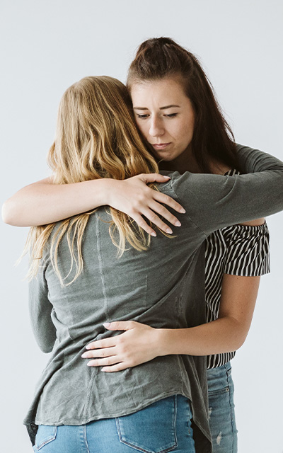 Woman hugging a sad charity worker